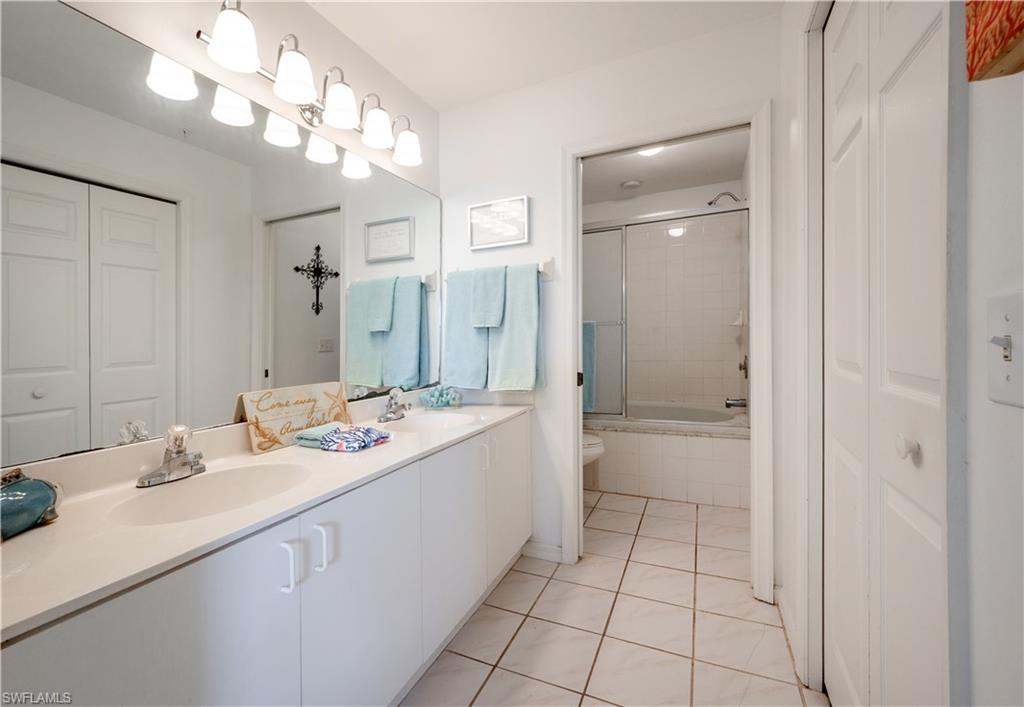 367 Dover Place, Unit 1002 Naples, FL 34104 - Photo 14 of 31 a bathroom with a sink a vanity and a mirror