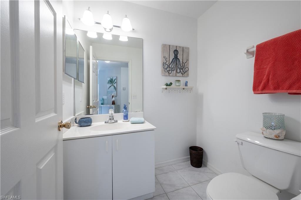 367 Dover Place, Unit 1002 Naples, FL 34104 - Photo 17 of 31 a bathroom with a toilet sink and mirror