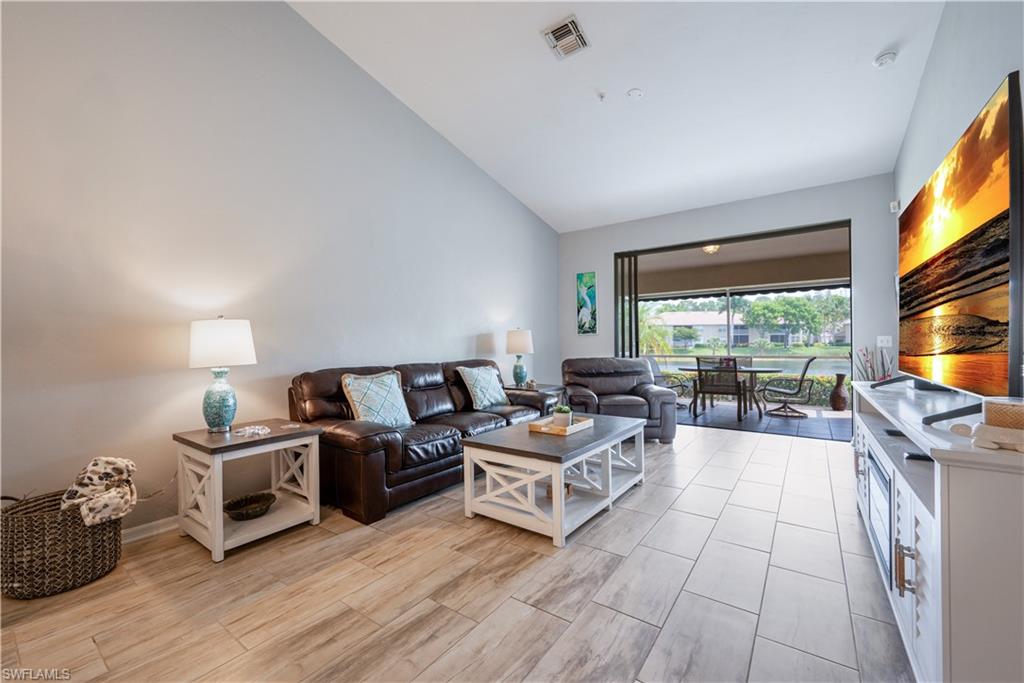 367 Dover Place, Unit 1002 Naples, FL 34104 - Photo 2 of 31 a living room with furniture flat screen tv and a large window