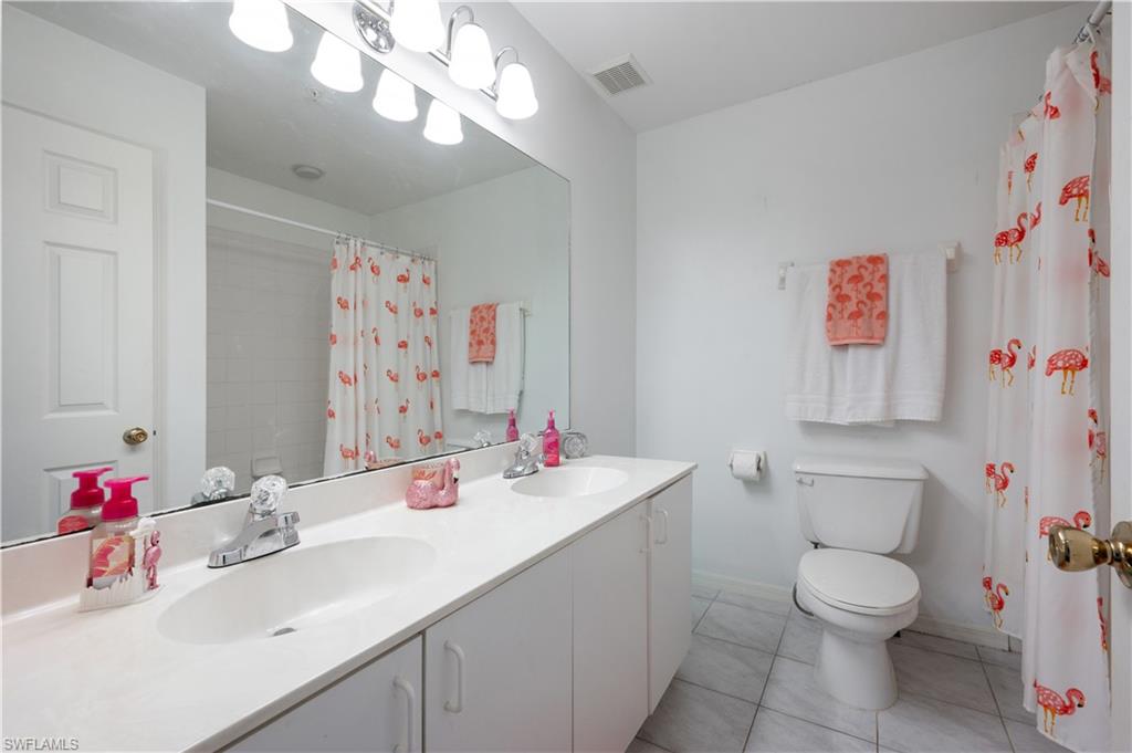 367 Dover Place, Unit 1002 Naples, FL 34104 - Photo 21 of 31 a bathroom with a sink vanity mirror and toilet