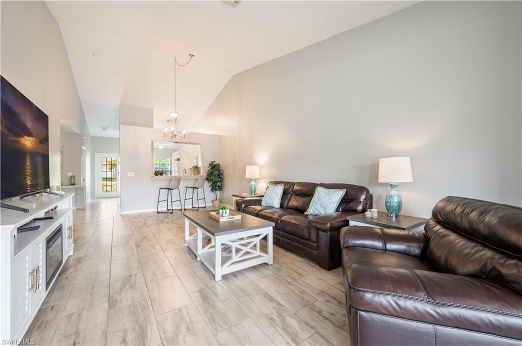 367 Dover Place, Unit 1002 Naples, FL 34104 - Photo 5 of 31 a living room with furniture and a flat screen tv