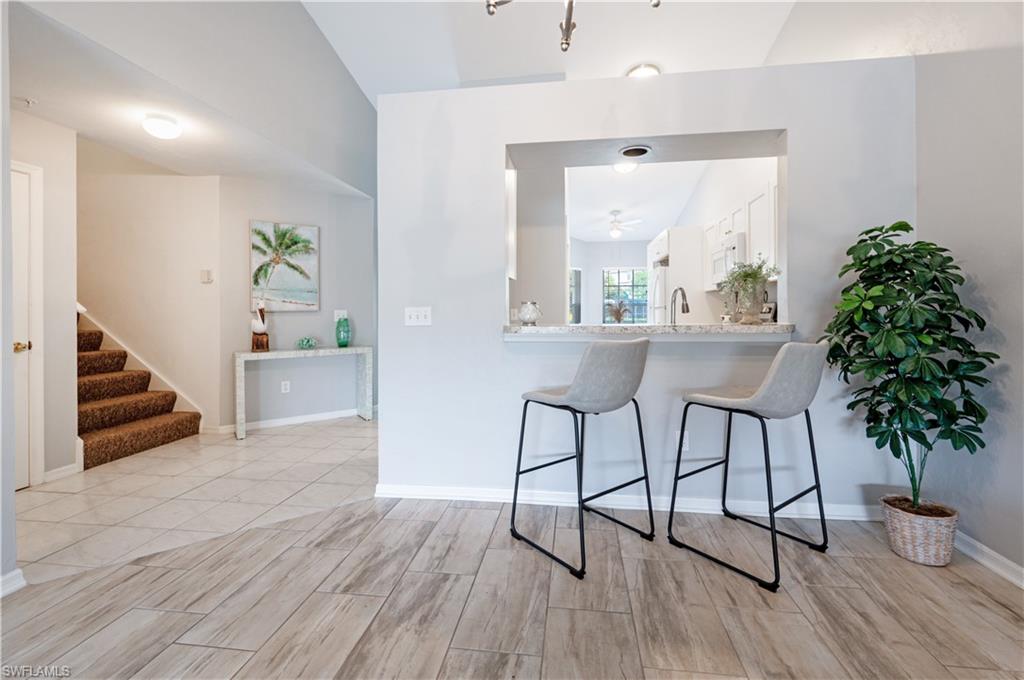 367 Dover Place, Unit 1002 Naples, FL 34104 - Photo 6 of 31 a view of a hallway kitchen with wooden floor and a potted plant