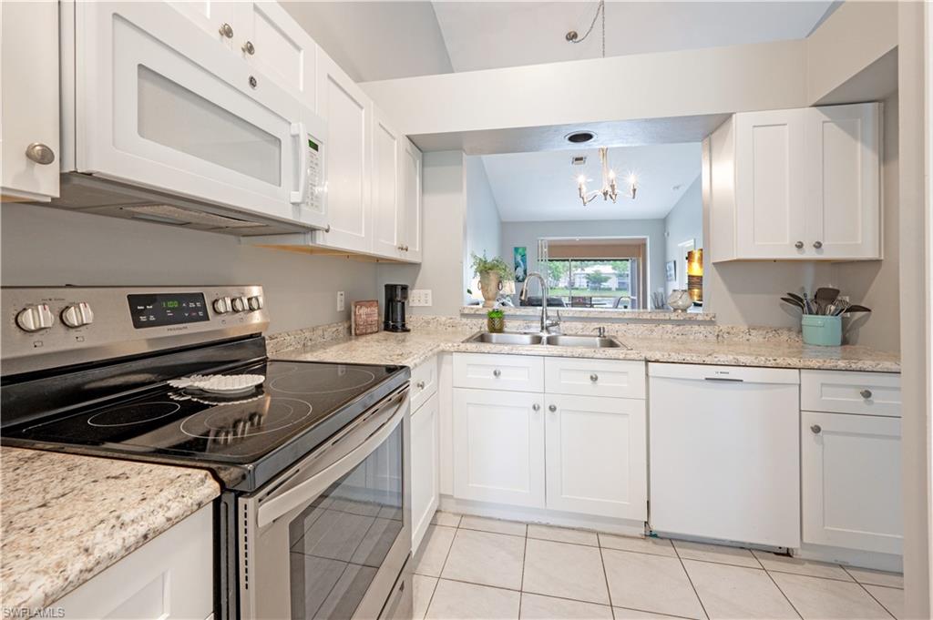 367 Dover Place, Unit 1002 Naples, FL 34104 - Photo 8 of 31 a kitchen with white cabinets and appliances