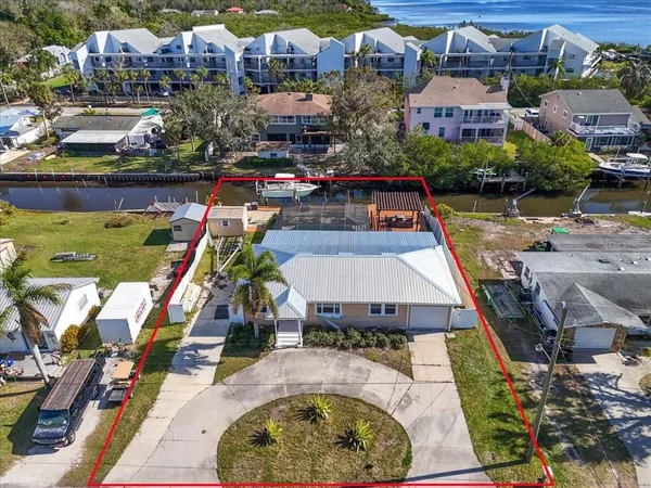 an aerial view of a house with a garden and lake view
