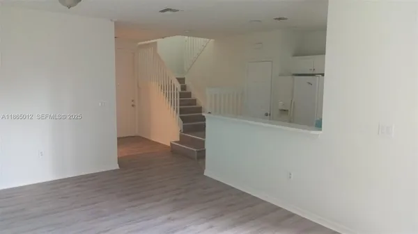 an empty room with wooden floor and entrance