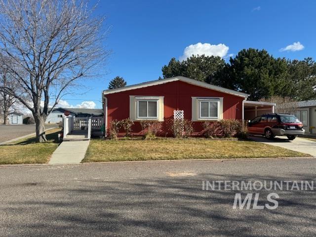 910 Moonglo, Unit 49 Buhl, ID 83316 - Photo 1 of 16 View of front of home featuring driveway, a front lawn, and a carport