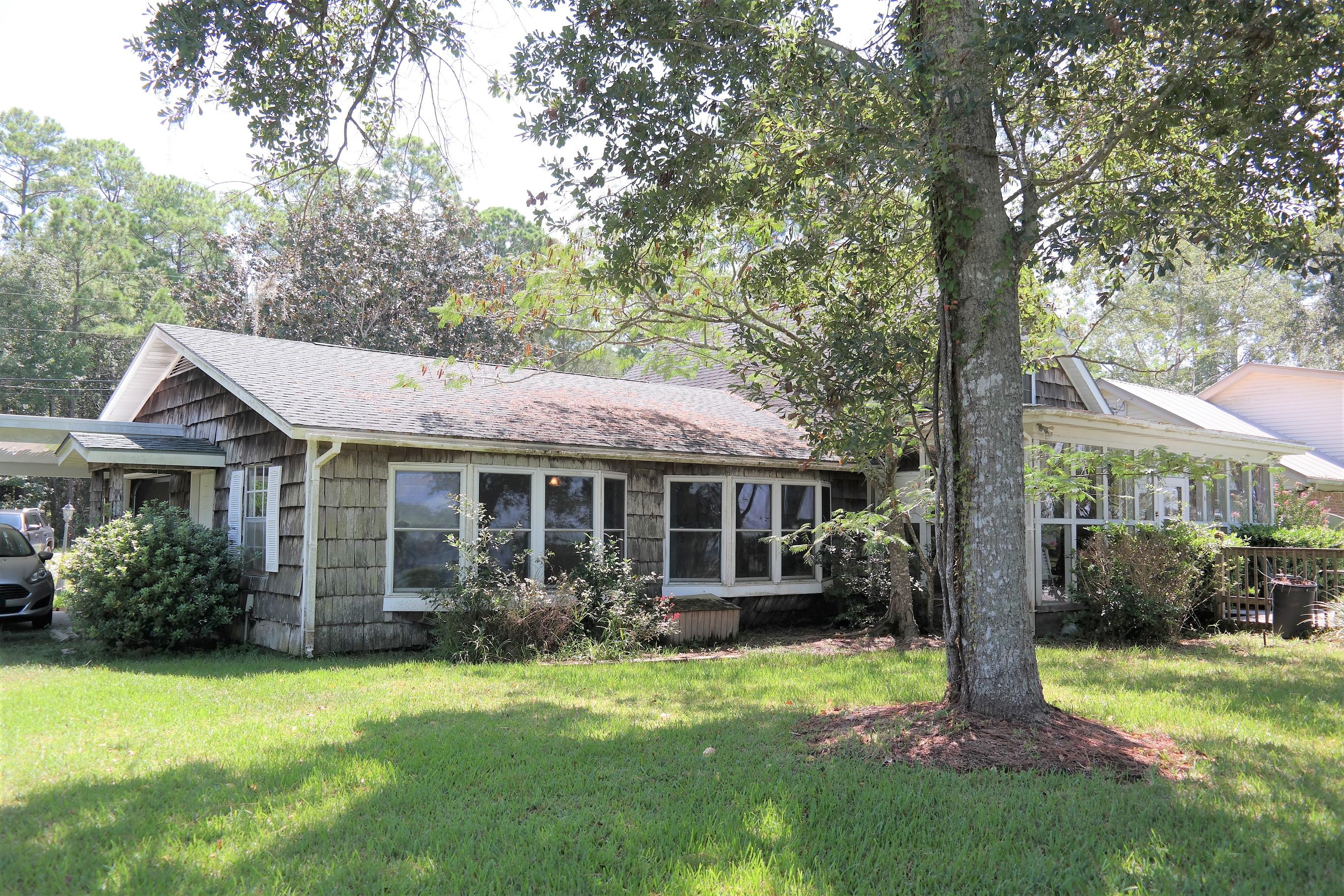 1824 Bay Grove Road Freeport, FL 32439 - Photo 47 of 51 a view of a house with brick walls and a yard with plants and large trees
