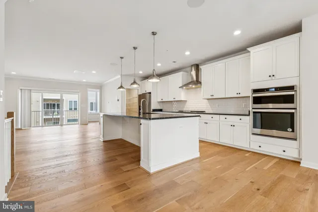 a large kitchen with cabinets and wooden floor