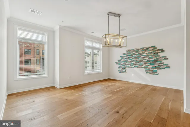 a view of an empty room with glass door and wooden floor