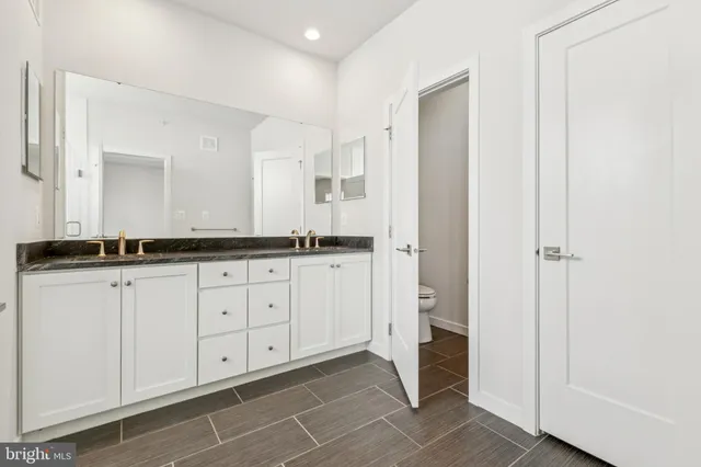 a spacious bathroom with a granite countertop sink and a mirror