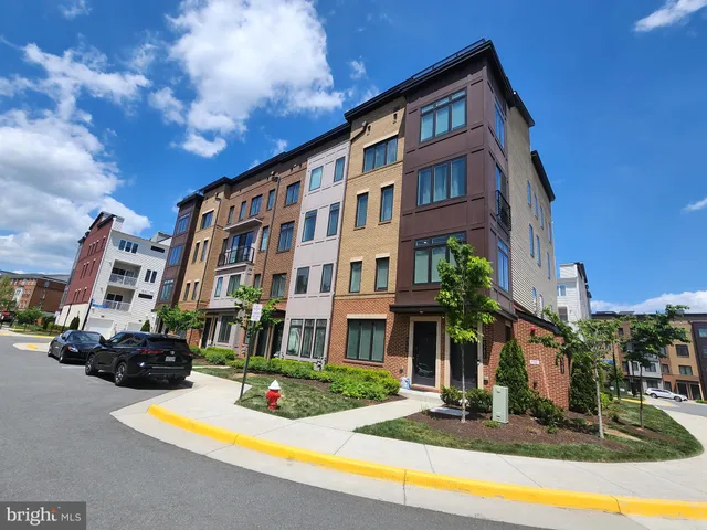a front view of a building with lot of cars and trees