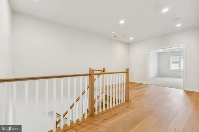 a view of a hallway with wooden floor and entryway