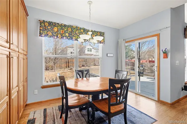 a dining room with furniture a chandelier and wooden floor