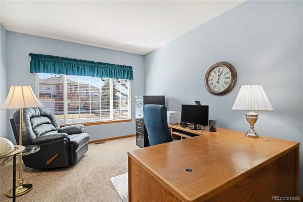 a living room with furniture a window and a clock