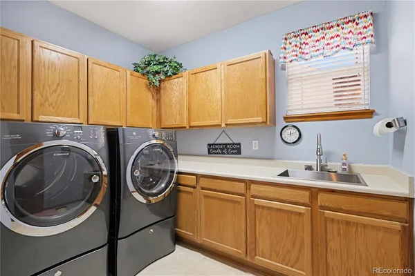 a utility room with sink dryer and washer