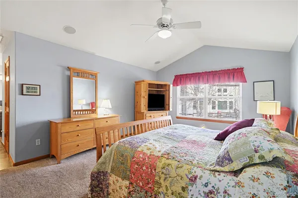 a bedroom with a large bed and a flat tv screen on dresser