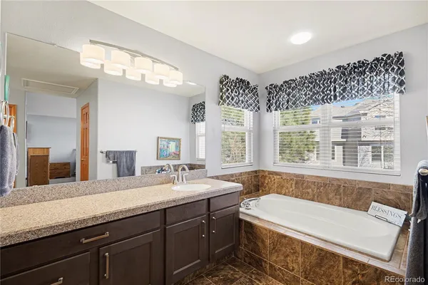 a bathroom with a bathtub a double vanity sink a toilet a mirror and shower