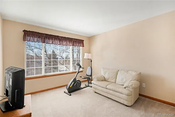 a living room with furniture a flat screen tv and a large window
