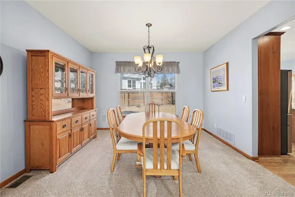 a dining room with furniture a chandelier and window
