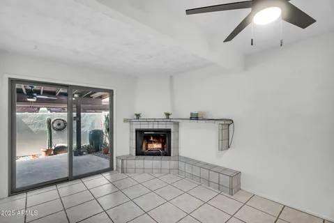 an empty room with windows and fireplace