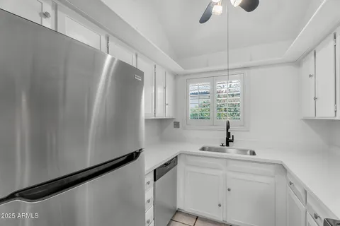 a view of a livingroom with a ceiling fan and staircase