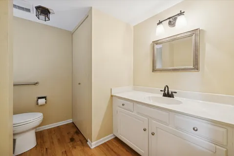 a bathroom with a granite countertop sink a toilet and a mirror