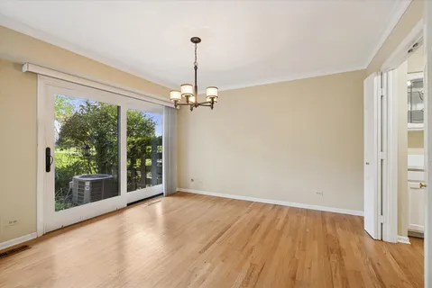a view of empty room with wooden floor fan and window