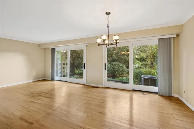 a view of an empty room with glass door and windows