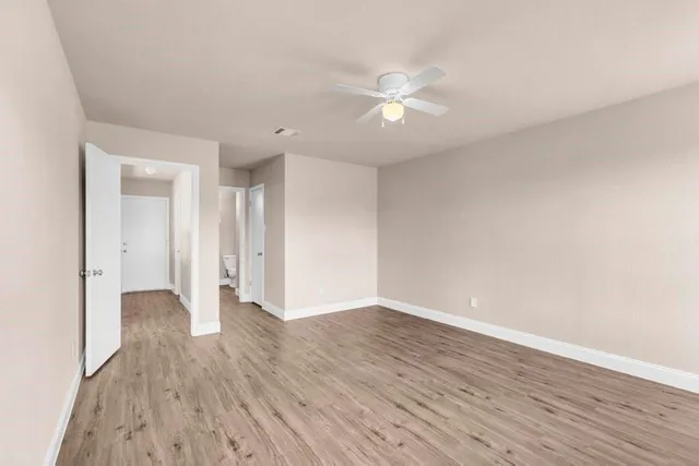 a view of an empty room with wooden floor