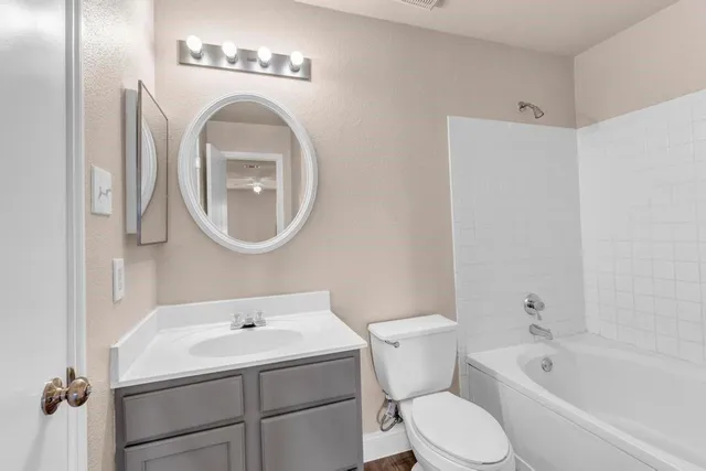 a white toilet sitting next to a bathroom sink and a tub