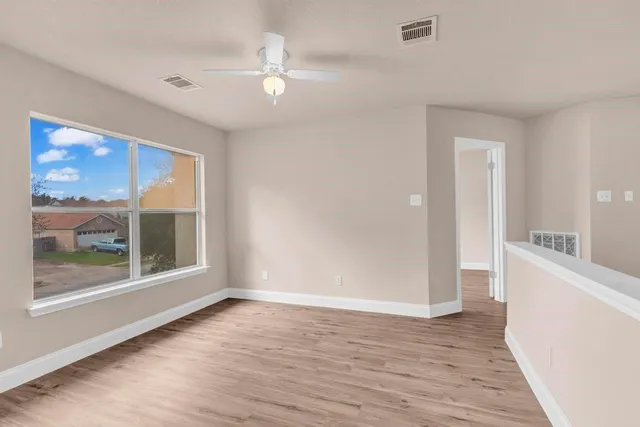 wooden floor in an empty room with a window