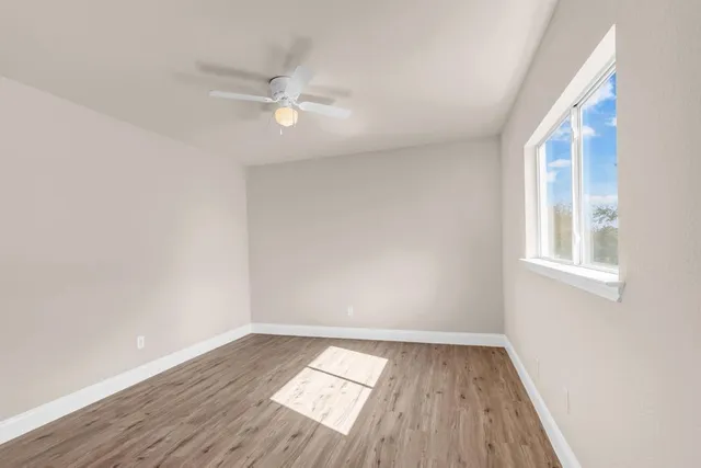 wooden floor in an empty room with a window