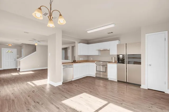 a kitchen with a refrigerator and white cabinets