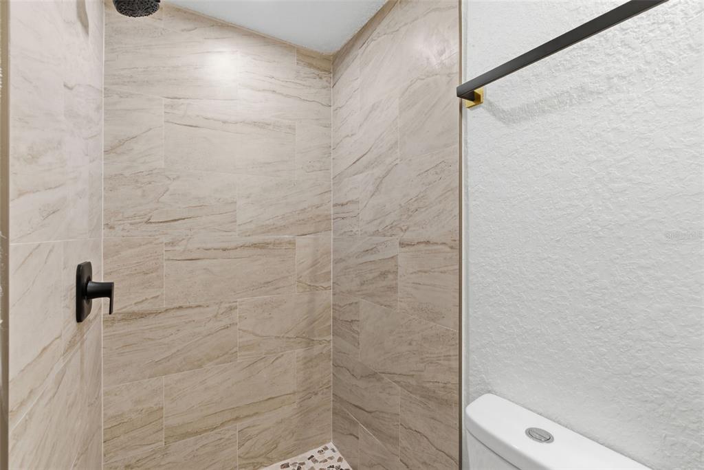 113 145th Avenue, Unit 4 Madeira Beach, FL 33708 - Photo 14 of 28 a bathroom with a shower and a toilet