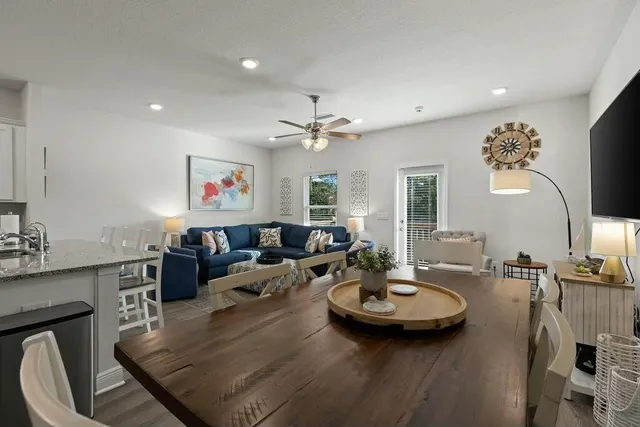 a living room with furniture kitchen view and a large mirror