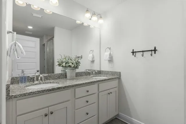 a bathroom with a granite countertop sink a large mirror and vanity