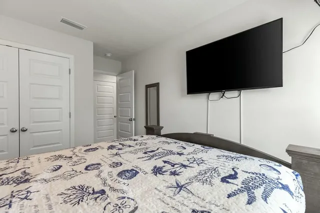 a bedroom with a bed and a flat screen tv