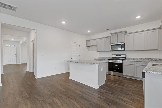a kitchen with granite countertop white cabinets and stainless steel appliances
