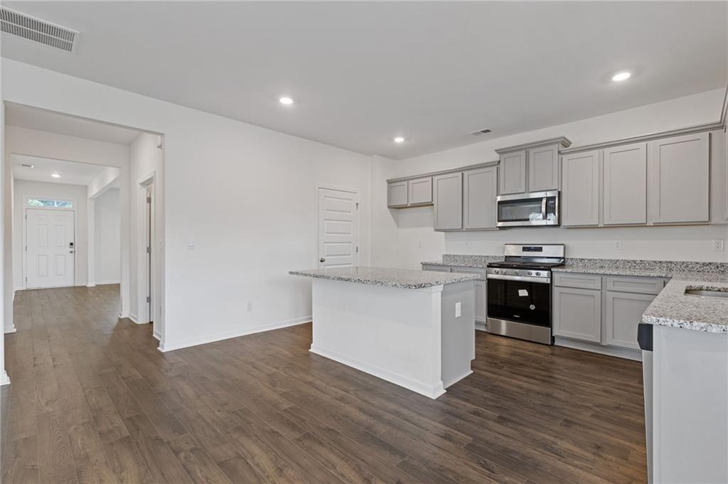 294 Ralph Still Road Dacula, GA 30019 - Photo 12 of 55 a kitchen with granite countertop white cabinets and stainless steel appliances
