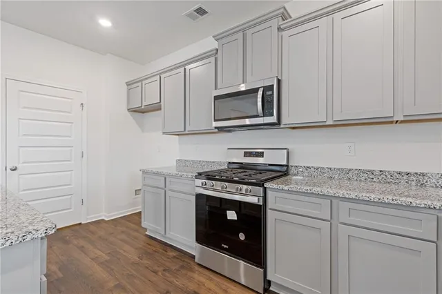 a kitchen with white cabinets and appliances