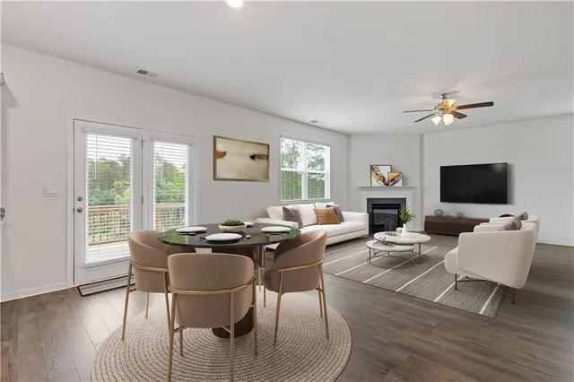 a living room with furniture a flat screen tv and a large window
