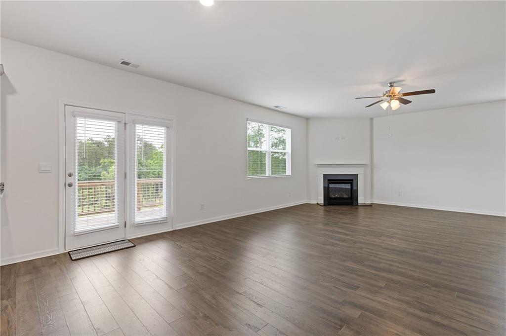 294 Ralph Still Road Dacula, GA 30019 - Photo 18 of 55 an empty room with wooden floor fan and windows