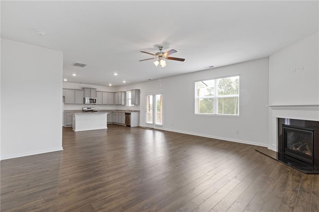 294 Ralph Still Road Dacula, GA 30019 - Photo 21 of 55 a view of an empty room with a kitchen and a fireplace