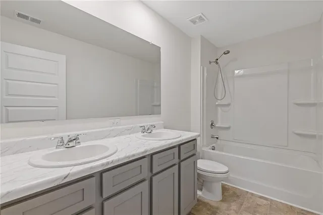 a bathroom with a granite countertop sink a toilet and a bathtub