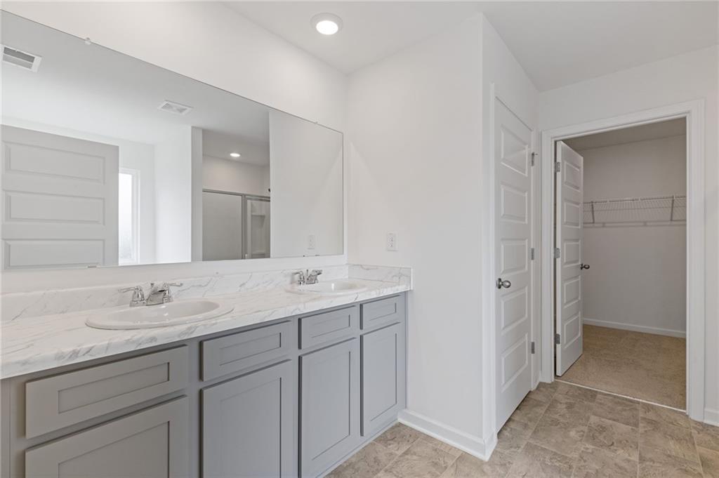 294 Ralph Still Road Dacula, GA 30019 - Photo 30 of 55 a bathroom with a double vanity sink and mirror