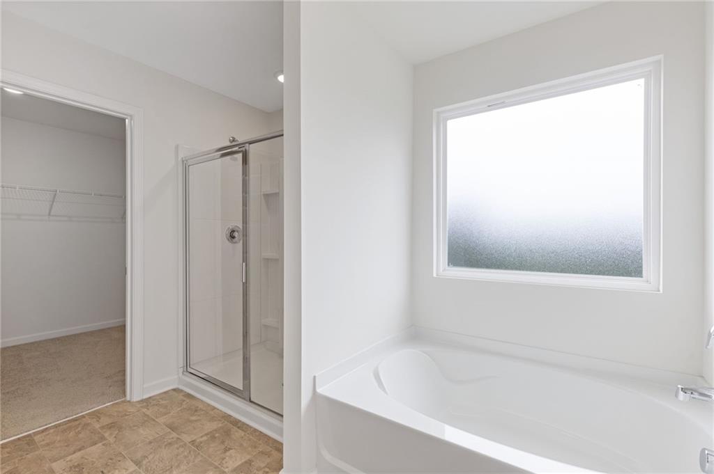 294 Ralph Still Road Dacula, GA 30019 - Photo 31 of 55 a bathroom with a bathtub and a shower