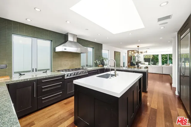 a kitchen with stainless steel appliances a stove a sink and a refrigerator