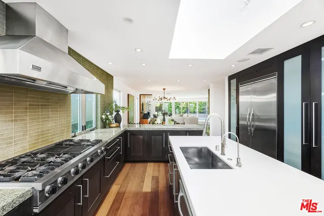 a spacious bedroom with a large bed and a chandelier