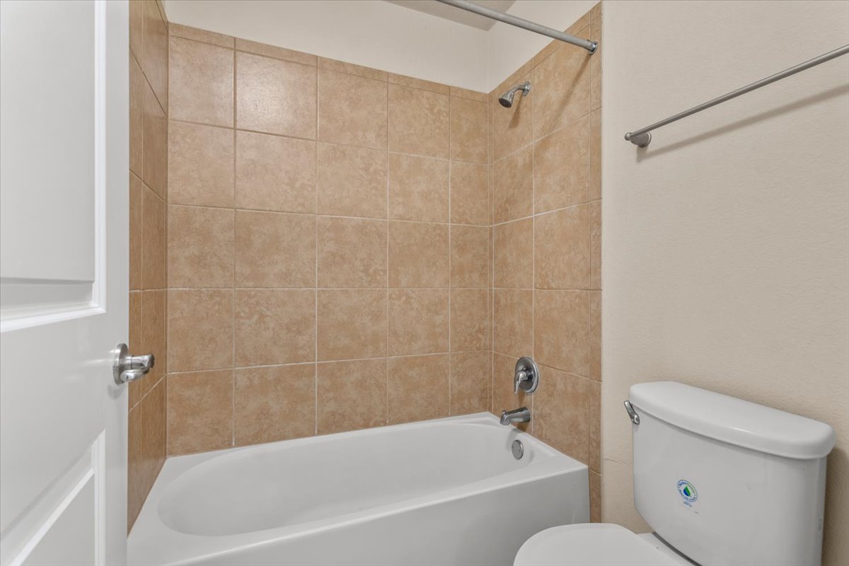 3451 Mayfield Ranch Boulevard, Unit 311 Round Rock, TX 78681 - Photo 28 of 40 Full-size bathtub with beige tile surround and polished chrome fixtures