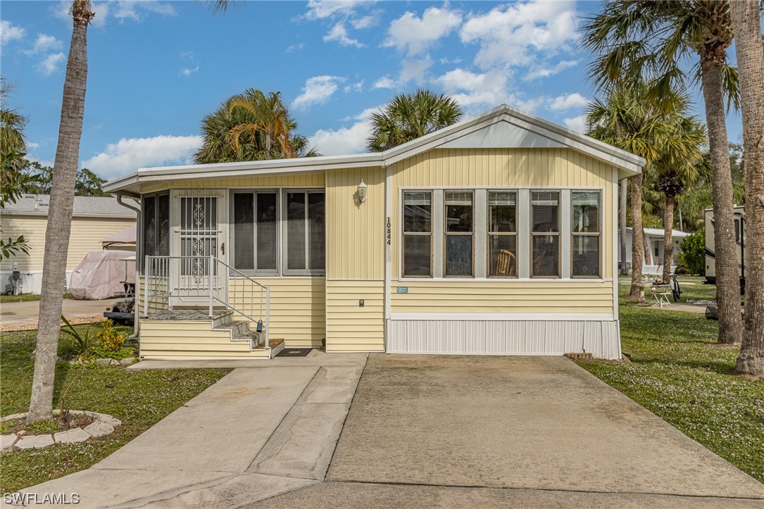 10844 Ani Circle Estero, FL 33928 - Photo 1 of 24 a front view of a house with a garden